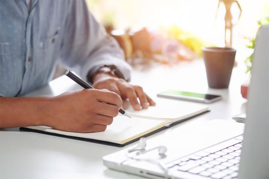 A virtual assistant writing something in front of the laptop