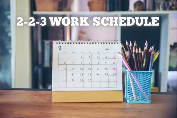 Desk calendar showing September with "2-2-3 Work Schedule" text and pencils in a holder.